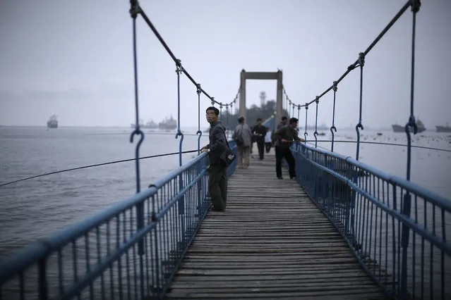 North Korean men fish off a pier leading to Jangdok Island on Tuesday, June 21, 2016, in Wonsan, North Korea. Wonsan, about 125 miles from Pyongyang, is a port city located in Kangwon Province, North Korea along the eastern side of the Korean Peninsula and was one of the cities chosen to be developed into a summer destination for locals as well as tourists (Photo by Wong Maye-E/AP Photo)