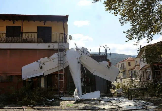 A small plane lays on a building after a crash in the village of Proti, near Serres town, northern Greece, on Monday, August 3, 2020. The single-engine plane crashed on Monday morning into the front of a small building but no injuries were reported and the pilot of the Cessna aircraft is well. (Photo by Ilias Kotsireas/InTime News via AP Photo)
