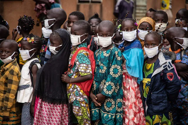 Pupils wearing face masks wait for the opening of their primary school on the first day of the new school year, in Ouagadougou, on October 1, 2020. (Photo by Olympia de Maismont/AFP Photo)