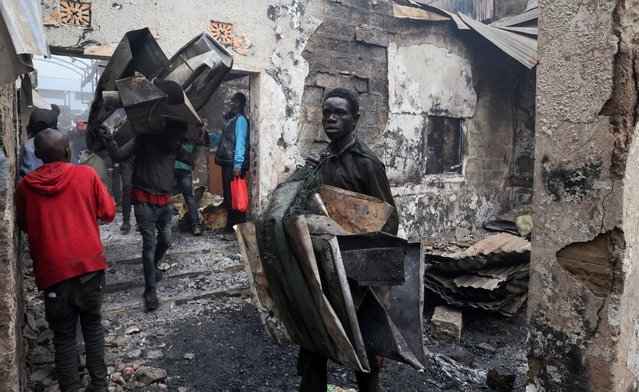 People salvage metal from the premises of businesses burnt during demonstrations to mark the first anniversary of the deadly 2024 anti-government protests that drew widespread condemnation over the use of force by security agencies, in downtown Nairobi, Kenya on June 26, 2025. (Photo by Monicah Mwangi/Reuters)