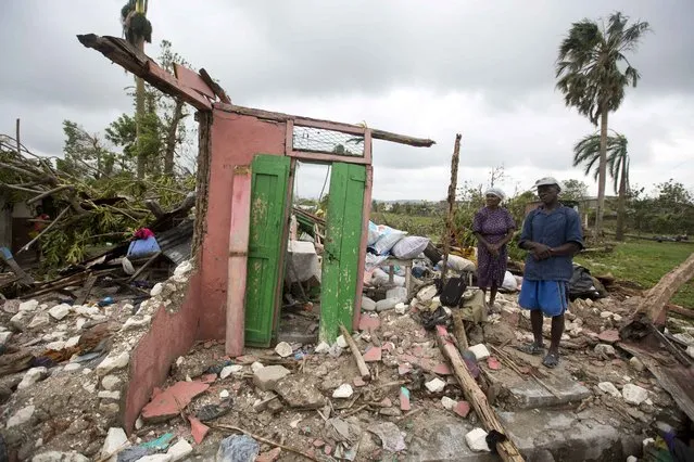 Saintanor Dutervil stands with his wife in the ruins of their home destroyed by Hurricane Matthew in Les Cayes, Haiti, Thursday, October 6, 2016. Two days after the storm rampaged across the country's remote southwestern peninsula, authorities and aid workers still lack a clear picture of what they fear is the country's biggest disaster in years. (Photo by Dieu Nalio Chery/AP Photo)