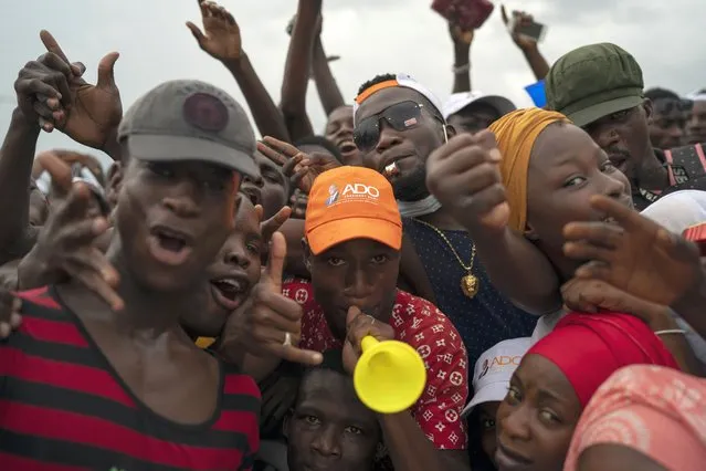 Supporters cheer for Ivory Coast President Alassane Ouattara before his arrival at a rally in Anyama, in the outskirts of Abidjan, Ivory Coast, Wednesday, October 28, 2020. Ouattara, who first came to power after the 2010 disputed election whose aftermath left more than 3,000 people dead, is now seeking a third term in office. The candidate maintains that he can serve a third term because of changes to the country's constitution, though his opponents consider his candidacy illegal. (Photo by Leo Correa/AP Photo)