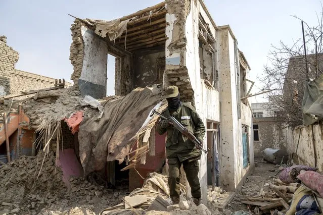 A Taliban fighter checks an Islamic State group house that was destroyed in the ongoing conflict between the two in Kabul, Afghanistan, Tuesday, February 14, 2023. Zabihullah Mujahid, senior Taliban government spokesman, said the raid in the capital city on Monday night targeted IS militants who organized recent attacks in Kabul. (Photo by Ebrahim Noroozi/AP Photo)