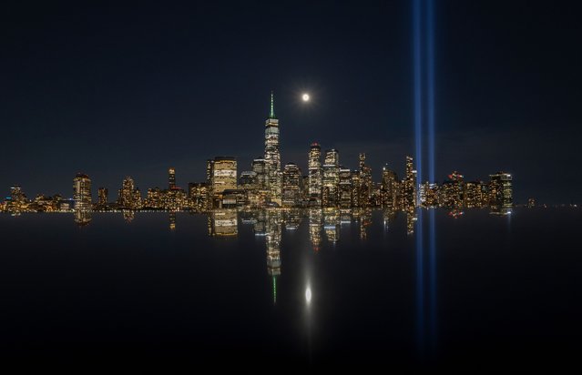 The Corn Moon rises behind the skyline of lower Manhattan and One World Trade Center as the Tribute in Light is tested ahead of the 24th anniversary of the 9/11 attacks in New York City on September 8, 2025, as seen from Jersey City, New Jersey. (Photo by Gary Hershorn/Getty images)