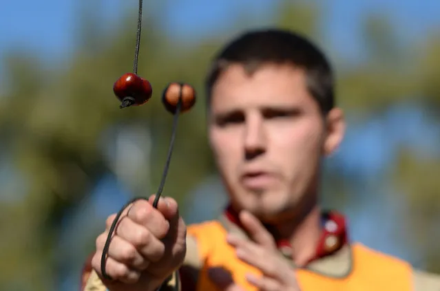 A competitor takes a shot during the 51st World Conker Championships at the Shuckburgh Arms in Southwick, Northamptonshire, UK on October 9, 2016. Conkers is a traditional children's game in Britain and Ireland played using the seeds of horse chestnut trees – the name “conker” is also applied to the seed and to the tree itself. The game is played by two players, each with a conker threaded onto a piece of string: they take turns striking each other's conker until one breaks. (Photo by Joe Giddens/PA Wire)