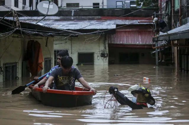 Rescuers assist trapped residents during a rescue operation in Providence village in Marikina City, east of Manila, Philippines, Thursday. November 12, 2020. (Photo by Basilio Sepe/AP Photo)