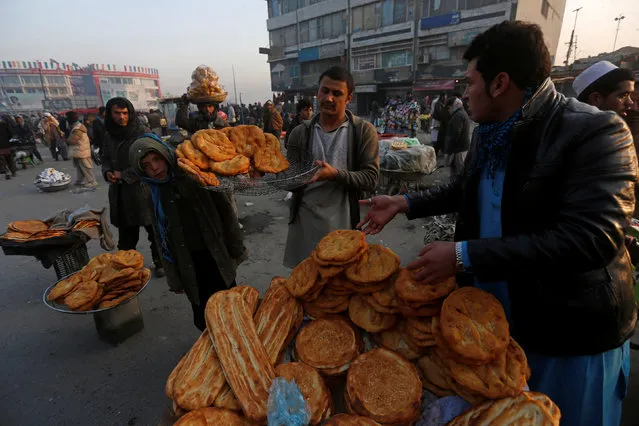 Afghan men place bread for sale at a market during the early morning hours in Kabul, Afghanistan, January 11, 2015. (Photo by Omar Sobhani/Reuters)