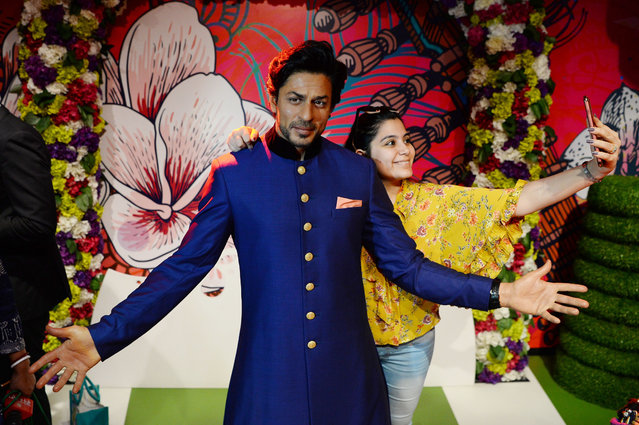 An Indian visitor takes a selfie with a waxwork of Bollywood actor Shah Rukh Khan after it was unveiled at Madame Tussauds Delhi in New Delhi on April 4, 2018. (Photo by  Sajjad Hussain/AFP Photo)