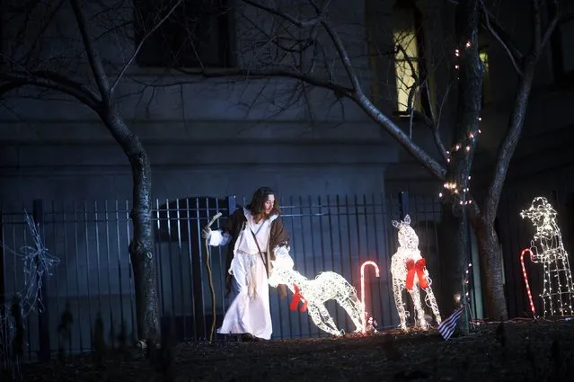 Michael Grant, 28, “Philly Jesus”, lifts a fallen Christmas decoration in the courtyard of Philadelphia City Hall in Philadelphia, Pennsylvania December 14, 2014. (Photo by Mark Makela/Reuters)