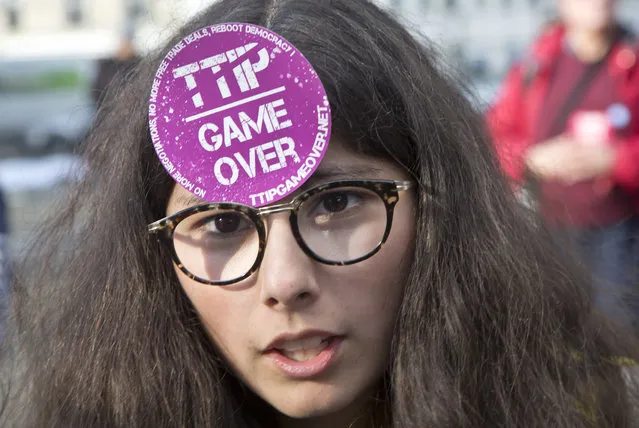 A protester has a sticker on her fore-head during a rally to protest against the trade deals with Canada and the U.S. in Paris, Saturday, October 15, 2016. Hundreds of people protested Saturday in Paris against free-trade agreements that the European Union is pursuing with the U.S. and Canada. (Photo by Michel Euler/AP Photo)