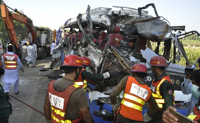 A Pakistani rescue team work on the wreckage of a deadly accident involving two buses, in Khanpur, Monday, October 17, 2016. Pakistani officials say the death toll from a head-on collision of two passenger buses in central Pakistan is over two dozen. They say tens of people were injured in the crash, many of whom remain in critical condition. Police say speeding seems to have been the cause of the accident, which occurred on a dangerous curve in Rahim Yar Khan district. (Photo by Waleed Saddique/AP Photo)
