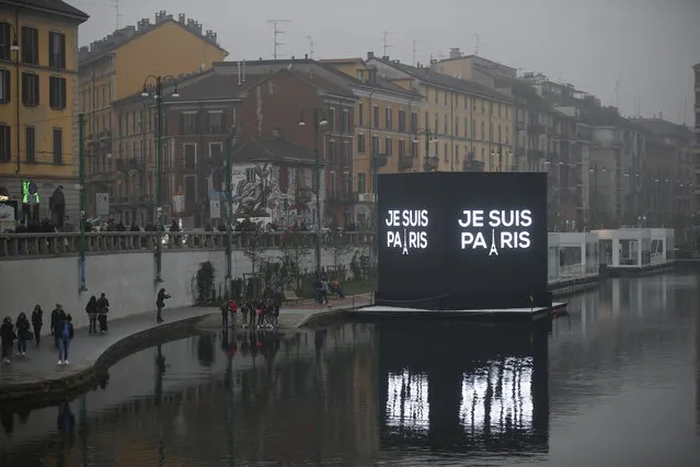 An electronic billboard on a canal in Milan, Italy, reads in French "I'm Paris", Saturday, November 14, 2015. French police on Saturday hunted possible accomplices of eight assailants who terrorized Paris concert-goers, cafe diners and soccer fans with a coordinated string of suicide bombings and shootings in France's deadliest peacetime attacks. (Photo by Luca Bruno/AP Photo)