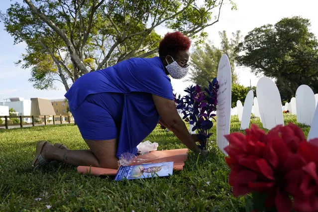 Sheila Roberts, 61, leaves flowers for her mother Lula M. Hunter-Roberts, who recently died at age 87 of COVID-19, at a symbolic cemetery created to remember and honor lives lost to the virus, Tuesday, December 15, 2020, in the Liberty City neighborhood of Miami. Roberts said her mother was a beautiful spirit inside and out, and that “she shined bright like a diamond”. (Photo by Lynne Sladky/AP Photo)