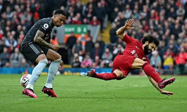 Arsenal's Brazilian defender Gabriel Magalhaes (L) tackles Liverpool's Egyptian striker Mohamed Salah during the English Premier League football match between Liverpool and Arsenal at Anfield in Liverpool, north west England on April 9, 2023. (Photo by Paul Ellis/AFP Photo)