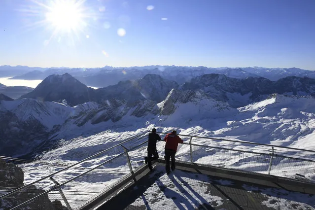 Two employees look out over the closed ski resort at the Zugspitze in Grainau, Germany, Monday, November 30, 2020. The skiing areas are prepared but due to the Corona pandemic restrictions skiing is not allowed at the area. (Photo by Angelika Warmuth/dpa via AP Photo)