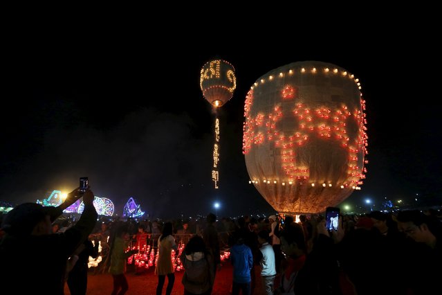 People look at lit traditional home-made balloons during the annual Tazaungdaing balloon festival in Taunggyi, Myanmar November 19, 2015. (Photo by Soe Zeya Tun/Reuters)