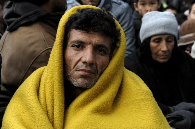 A man is covered with a blanket as migrants wait to cross the Greek-Macedonian borders near the village of Idomeni, Greece November 22, 2015. (Photo by Alexandros Avramidis/Reuters)