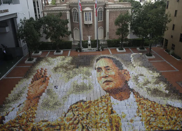 A mosaic portrait of the late Thai King Bhumibol Adulyadej is displayed as the 1,250 students practice flipping boards, at Assumption College in Bangkok, Thailand, Friday, October 28, 2016. King Bhumibol died Oct. 13 after reigning for 70 years, plunging the country into grief and extended mourning. The official mourning period is one year. (Photo by Sakchai Lalit/AP Photo)