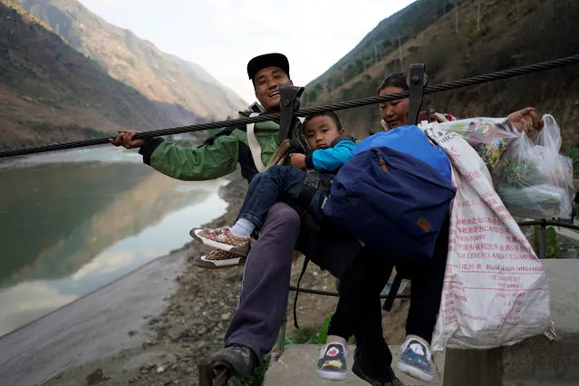 A family is ready to zip their way back to Lazimi village after shopping at the Saturday market in Nujiang Lisu Autonomous Prefecture in Yunnan province, China, March 24, 2018. Most villagers, who are members of the Lisu ethnic group and are deeply religious, also zip across every Sunday for mass services at nearby churches. The nearest bridge over the river is 12 miles away from the mountainside village. (Photo by Aly Song/Reuters)