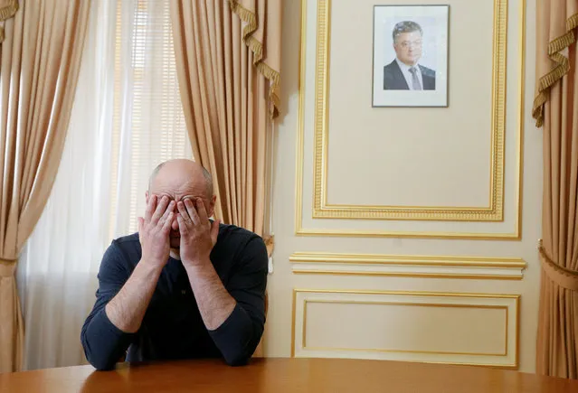 Russian dissident journalist Arkady Babchenko touches his face during an interview with foreign media, with a portrait of Ukrainian President Petro Poroshenko seen in the background, in Kiev, Ukraine May 31, 2018. (Photo by Valentyn Ogirenko/Reuters)