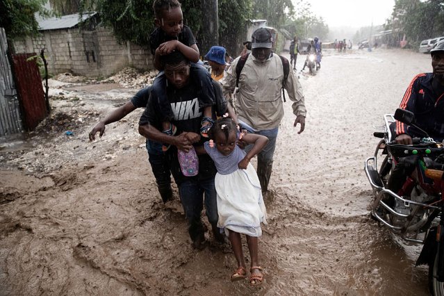People walk through a flooded street in Petit-Goâve, Haiti, on Thursday, October 30, 2025. Hurricane Melissa did not make direct landfall in Haiti, but it caused significant damage there and at least 23 deaths due to severe flooding and landslides. (Photo by Clarens Siffroy/AFP Photo)