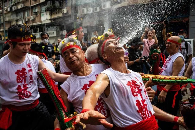 Performers dance and spray rice wine during the Drunken Dragon celebration that is believed to bring prosperity and safety to the fishing community in Macau, on May 26, 2023. (Photo by Eduardo Leal/AFP Photo)