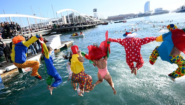 Participants in fancy costumes jump into the water during the 115th edition of the Copa Nadal (Christmas Cup) swimming race in Barcelona's Port Vell on December 25, 2024. The traditional 200-meter Christmas swimming race gathered more than 450 participants on Barcelona's Port Vell. (Photo by Josep Lago/AFP Photo)