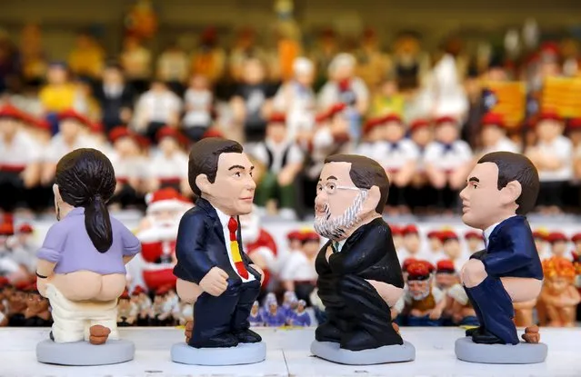 Clay "caganers" representing Spanish Prime Minister Mariano Rajoy (2nd R), Podemos's candidate Pablo Iglesias (L), Socialist Party (PSOE) leader Pedro Sanchez (2nd L) and Ciudadanos party leader Albert Rivera (R) are seen on display at the Santa Llucia Christmas market in central Barcelona, Spain, December 16, 2015. (Photo by Albert Gea/Reuters)