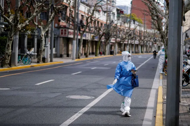 A worker in a protective suit keeps watch on a street, as the second stage of a two-stage lockdown to curb the spread of the coronavirus disease (COVID-19) begins in Shanghai, China on April 1, 2022. (Photo by Aly Song/Reuters)
