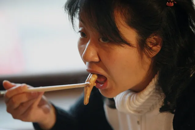 A Chinese woman eats from an ox and dog pen*s dish at the Guolizhuang “strength in the pot” pen*s restaurant in China's capital Beijing March 3, 2006. The restaurant offers more than 30 types of animal penises served in a Chinese hotpot style. According to the theory of traditional Chinese medicine, the pen*s of certain animals is full of nutrients which brings men energy. And because it contains gelatine albumen, it is said to have excellent cosmetic effects for women, especially beneficial for the skin. (Photo by Reinhard Krause/Reuters)