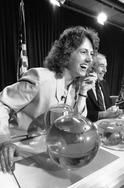 Space teacher Christa McAuliffe responds to a question at a press conference at the Johnson Space Center in Houston, Texas, December 13, 1985. In front of McAuliffe is the Hughes fluid experiment that will fly on her mission, seated next to McAuliffe is Hughes payload specialist Gregory B. Jarvis. (Photo by R.J. Carson/AP Photo)