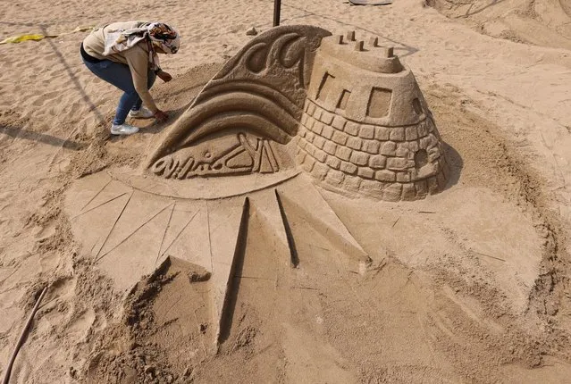 Dr. Yasmena Rady, Fine Arts professor at Damietta University, works on her project, “Alexandria Citadel” during the competition for the best sand sculptures, in the “Alexandria Sand Sculpture Festival”, to promote tourism and mark the beginning of summer, at Al Saraya public beach, in Alexandria, Egypt on May 9, 2023. (Photo by Amr Abdallah Dalsh/Reuters)