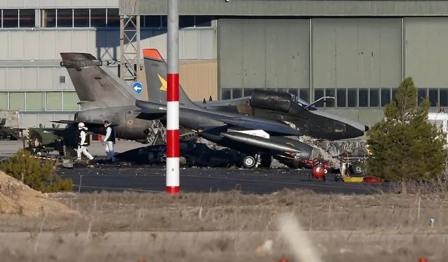 People wearing protective suits walk past the wreckage of a Greek F-16 fighter plane which crashed after taking off, inside the Los Llanos military base in Albacete, central Spain, January 27, 2015. A French serviceman who was severely injured when the plane crashed on Monday died in hospital in Madrid on Tuesday, bringing the death toll from the accident to 11 people, a ministry of defense spokesman said. (Photo by Sergio Perez/Reuters)