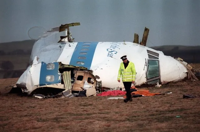 A policeman walks nearby the cockpit of the 747 Pan Am Boeing that exploded over Lockerbie on December 21, 1988, killing all 259 on board and 11 on the ground. Seven-year-old air, arms and diplomatic sanctions against Libya were suspended 05 April 1999, after Libya handed over the two suspects wanted in connection with the bombing. (Photo by EPA Photo/AFP Files/LETKEY)