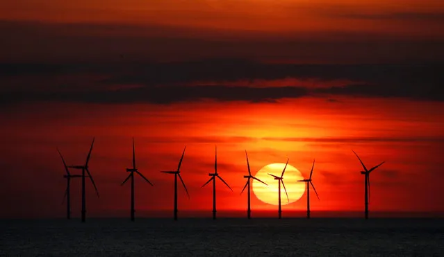 The sun sets behind the Burbo Bank wind farm near New Brighton, Britain, May 22, 2018. (Photo by Phil Noble/Reuters)