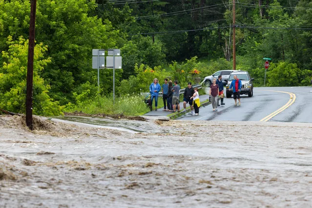 Onlookers check out a flooded road on July 10, 2023 in Chester, Vermont. Torrential rain and flooding has affected millions of people from Vermont south to North Carolina. (Photo by Scott Eisen/Getty Images)