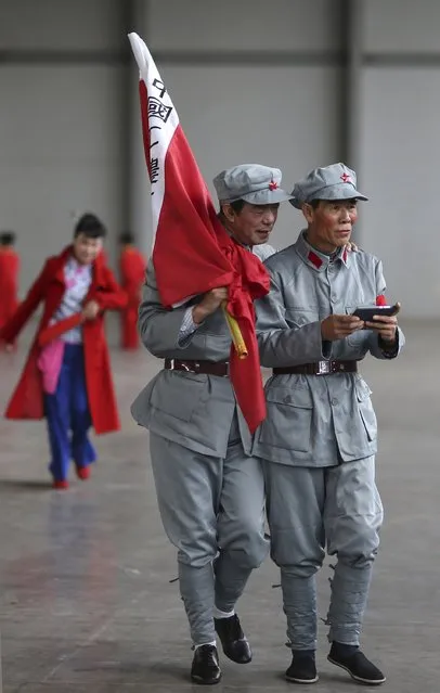 Participants dressed as Red Army soldiers look at a mobile phone as they wait backstage before their performance at a line dancing competition in Kunming, Yunnan province January 31, 2015. Hundreds of residents in about 60 dancing groups attended the competition which kicked off on Saturday and will last for eight days, local media reported. (Photo by Reuters/Stringer)