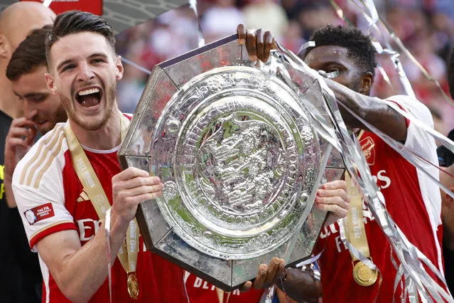 Arsenal's Declan Rice, left, lifts the trophy after winning the English FA Community Shield final soccer match between Arsenal and Manchester City at Wembley Stadium in London, Sunday, August 6, 2023. (Photo by David Cliff/AP Photo)