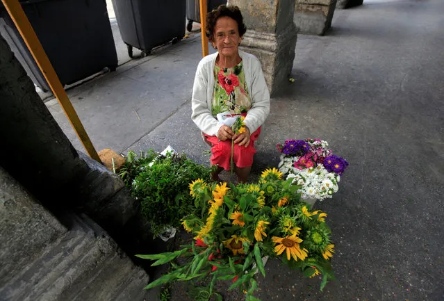 Alida Perez, 84, offers flowers for sale on a street in Havana, Cuba November 27, 2016. (Photo by Enrique De La Osa/Reuters)
