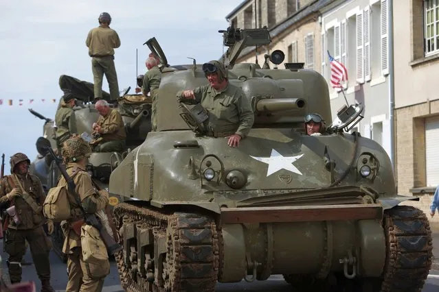 World War II history enthusiasts parade in WWII vehicles to commemorate the 78th anniversary of D-Day that led to the liberation of France and Europe from the German occupation, in Sainte-Mere-L'Eglise, Normandy, Sunday, June, 5, 2022. On Monday, the Normandy American Cemetery and Memorial, home to the gravesites of 9,386 who died fighting on D-Day and in the operations that followed, will host U.S. veterans and thousands of visitors in its first major public ceremony since 2019. (Photo by Jeremias Gonzalez/AP Photo)