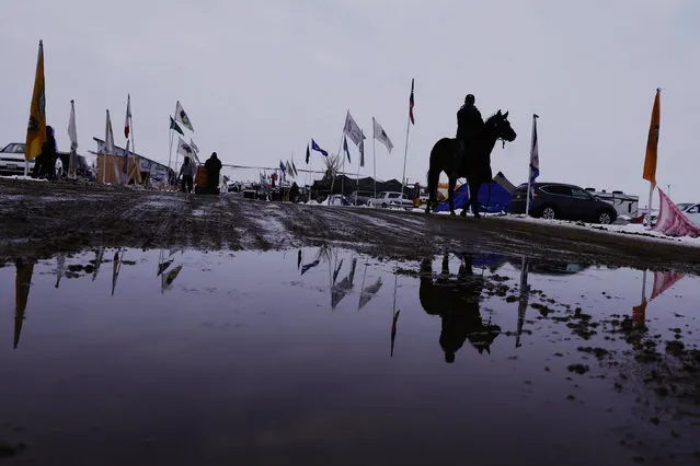 A man rides a horse down a road inside of the Oceti Sakowin camp as “water protectors” continue to demonstrate against plans to pass the Dakota Access pipeline near the Standing Rock Indian Reservation, near Cannon Ball, North Dakota, U.S., December 2, 2016. (Photo by Lucas Jackson/Reuters)