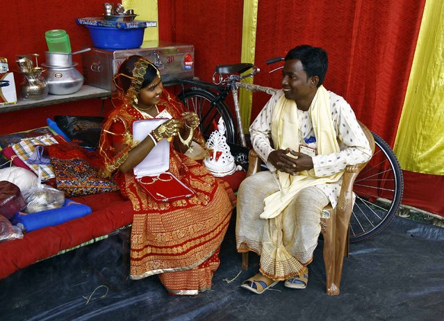 A newly-married couple share a moment after taking their wedding vows at a mass marriage ceremony at Bahirkhand village, north of Kolkata February 8, 2015. (Photo by Rupak De Chowdhuri/Reuters)