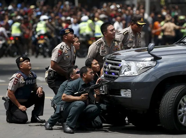 Police officers react near the site of a blast in Jakarta, Indonesia, January 14, 2016. Several explosions went off and gunfire broke out in the centre of the Indonesian capital on Thursday and police said they suspected a suicide bomber was responsible for at least one the blasts. (Photo by Darren Whiteside/Reuters)
