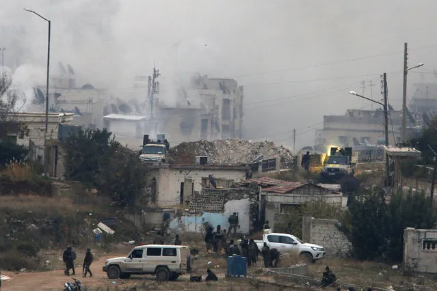 Pro-Syrian government soldiers shoot a weapon on the back of a vehicle near damaged buildings, in al-Izaa area in Aleppo, Syria December 5, 2016. (Photo by Omar Sanadiki/Reuters)