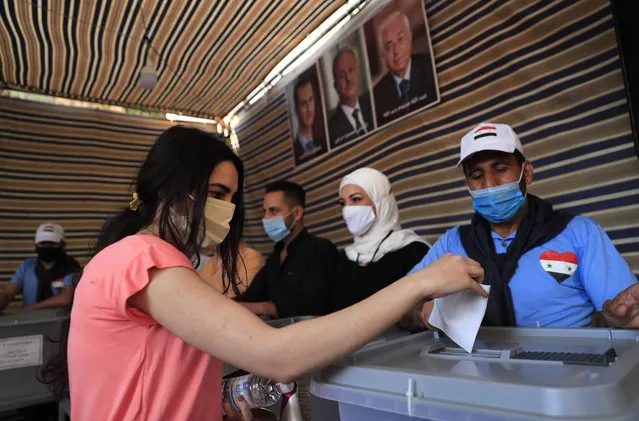 A Syrian woman who lives in Lebanon, casts her ballot for his country's presidential election at the Syrian embassy in Yarze, east of Beirut, Lebanon, Thursday, May 20, 2021. The expat ballot started in embassies abroad ahead of Syria's May 26 presidential election. (Photo by Hussein Malla/AP Photo)
