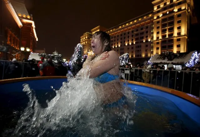 A woman takes a dip in a font on the eve of the Orthodox Epiphany in central Moscow, Russia, January 18, 2016. (Photo by Sergei Karpukhin/Reuters)