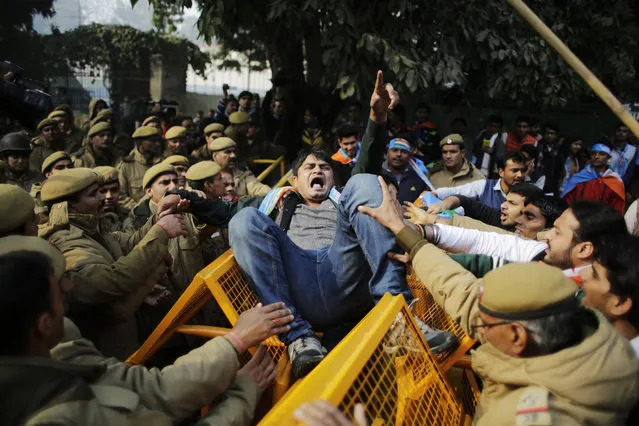A member of the National Students Union of India (NSUI), the student wing of India's main opposition Congress party, shouts slogans as he got entangled in police barricade during a protest against the death of Rohith Vemula in New Delhi, India, Friday, January 22, 2016. The students were protesting the death of Vemula who, along with four others, was barred from using some facilities at his university in the southern tech-hub of Hyderabad. (Photo by Altaf Qadri/AP Photo)