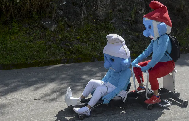Participants fancy dressed assmurfs attend the XXVII Car Festival before going downhill in a homemade cart in the Santa Elena Municipality, near Medellin, Antioquia department, Colombia, on December 18, 2016. (Photo by Raul Arboleda/AFP Photo)