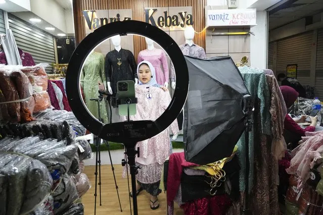 A trader conducts live sales via streaming at a store in the Tanah Abang textile market in Jakarta, Indonesia Thursday, September 28, 2023. Chinese-owned app TikTok on Thursday said it regretted the Indonesian government's decision to ban e-commerce transactions on social media platforms, particularly the impact it would have on the millions of sellers who use TikTok Shop. (Photo by Tatan Syuflana/AP Photo)