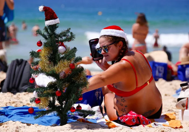 Irish backpacker Genna Woods adjusts her small Christmas tree she planted in the sand as she celebrates Christmas Day at Sydney's Bondi Beach in Australia, December 25, 2016. (Photo by David Gray/Reuters)